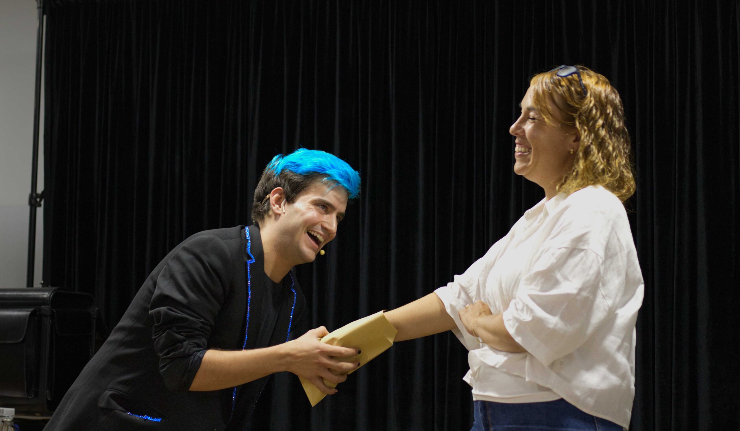 Mago para eventos Ivan Torres con espectadora con mano dentro de un sobre