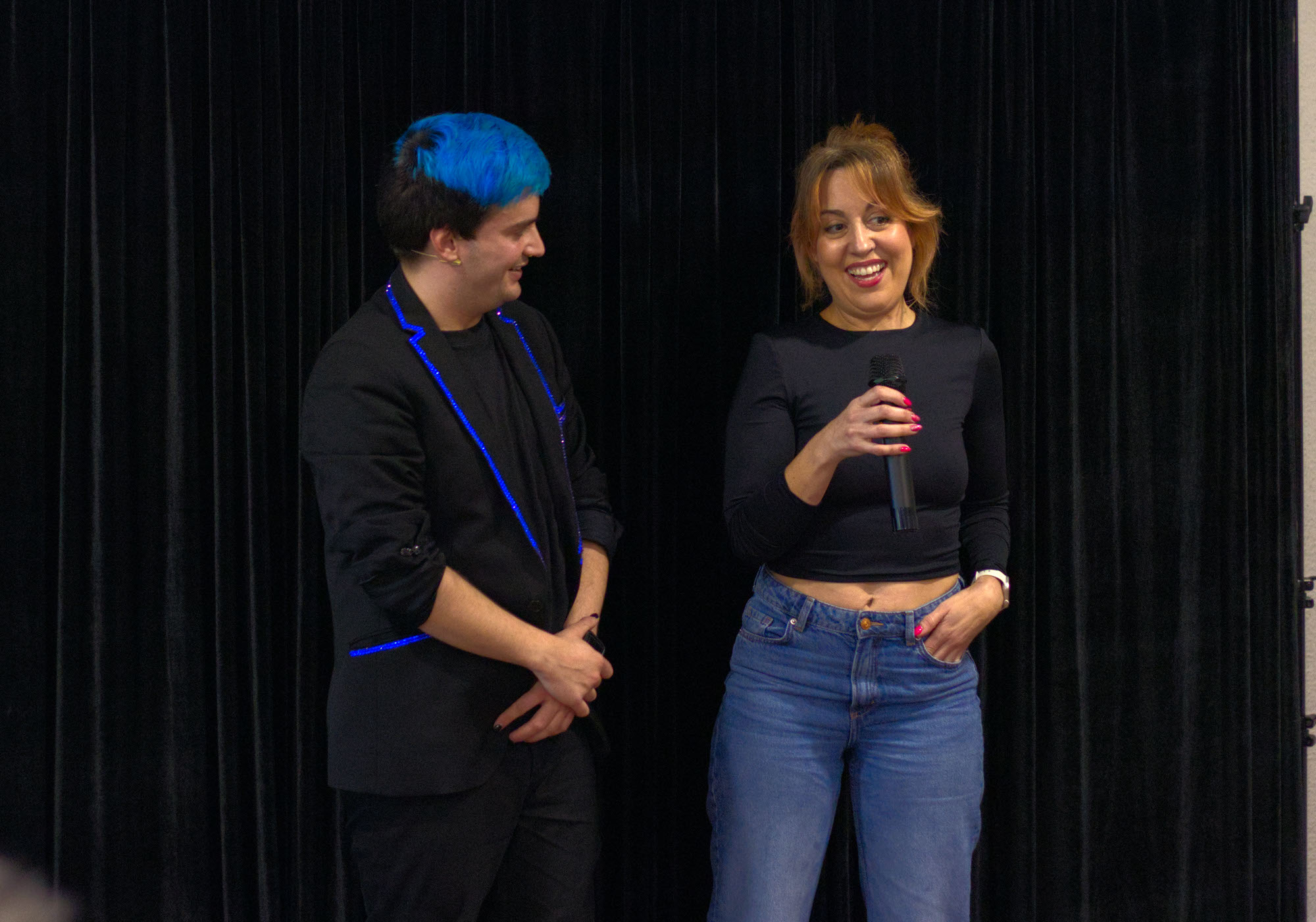 Mago para adultos Ivan Torres junto a una mujer con un micrófono de la mano