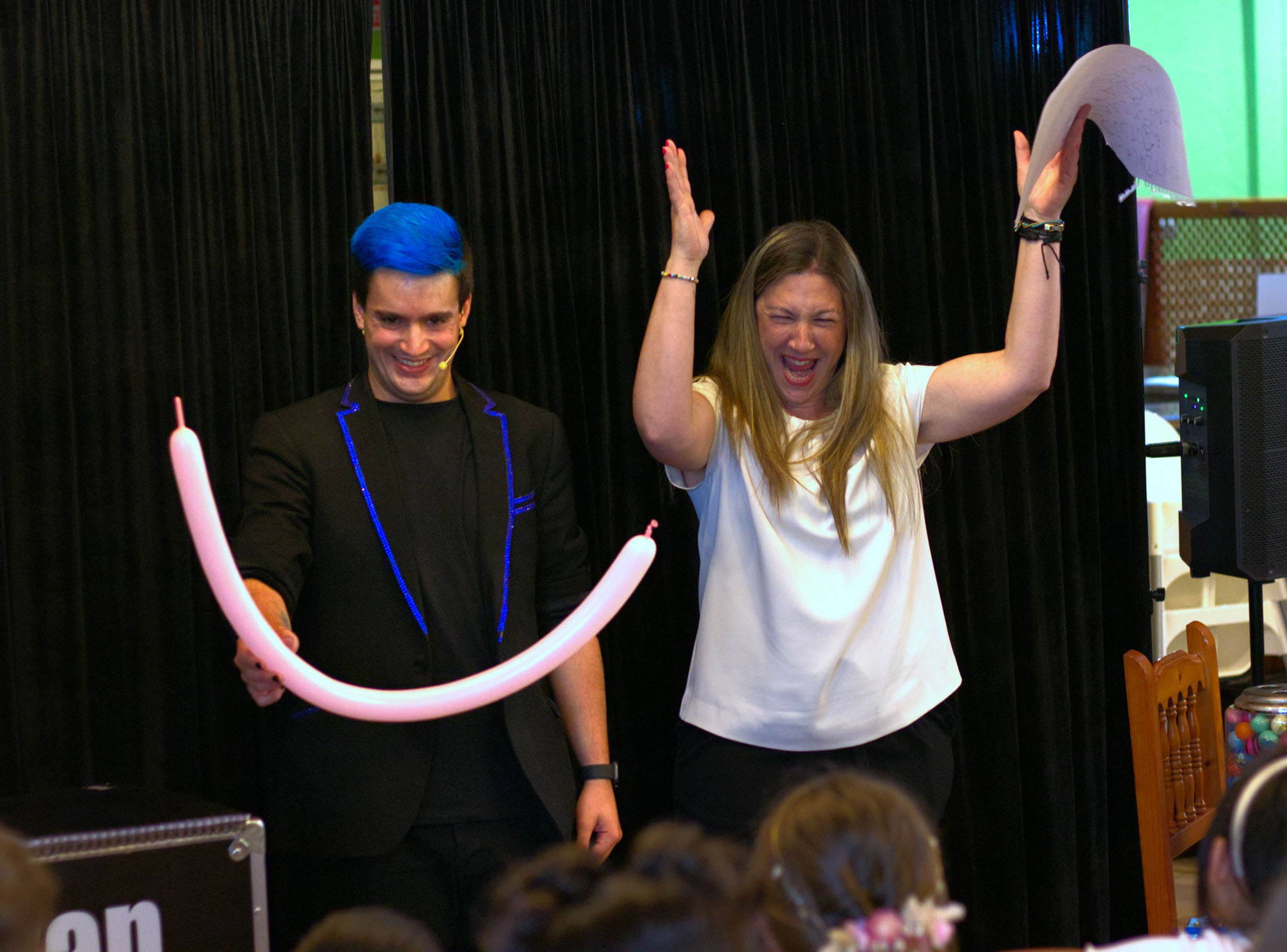 Mago para comuniones y eventos Ivan Torres con un globo en la mano y una mujer celebrandolo