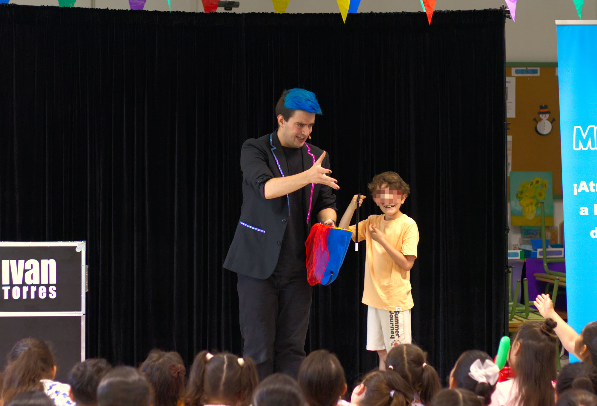 Mago para colegios Ivan Torres señalándo al público mientras niño se ríe con una varita rota en la mano