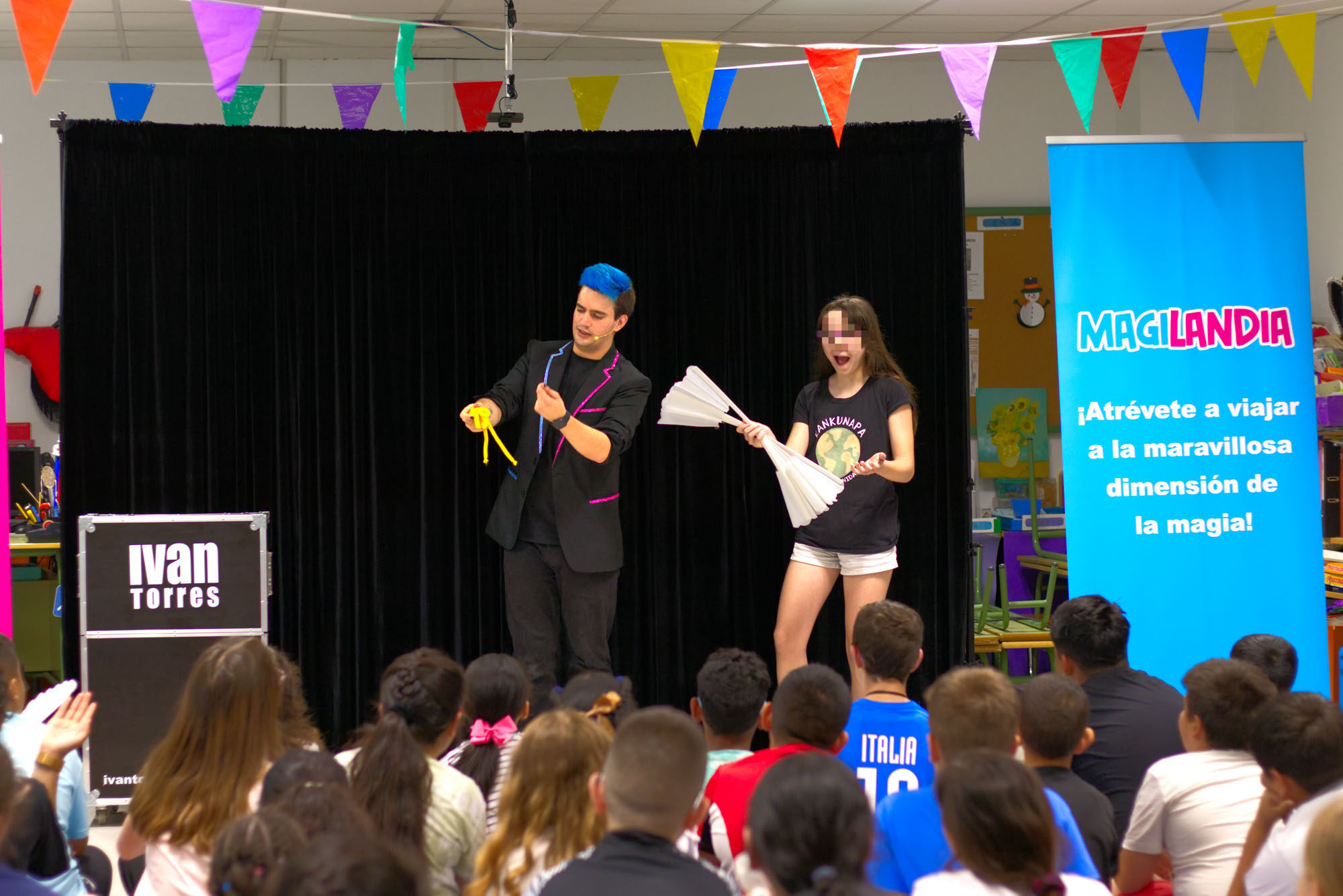 Chica con un abanico roto flipando mientras el mago para colegios Ivan Torres explicando la magia