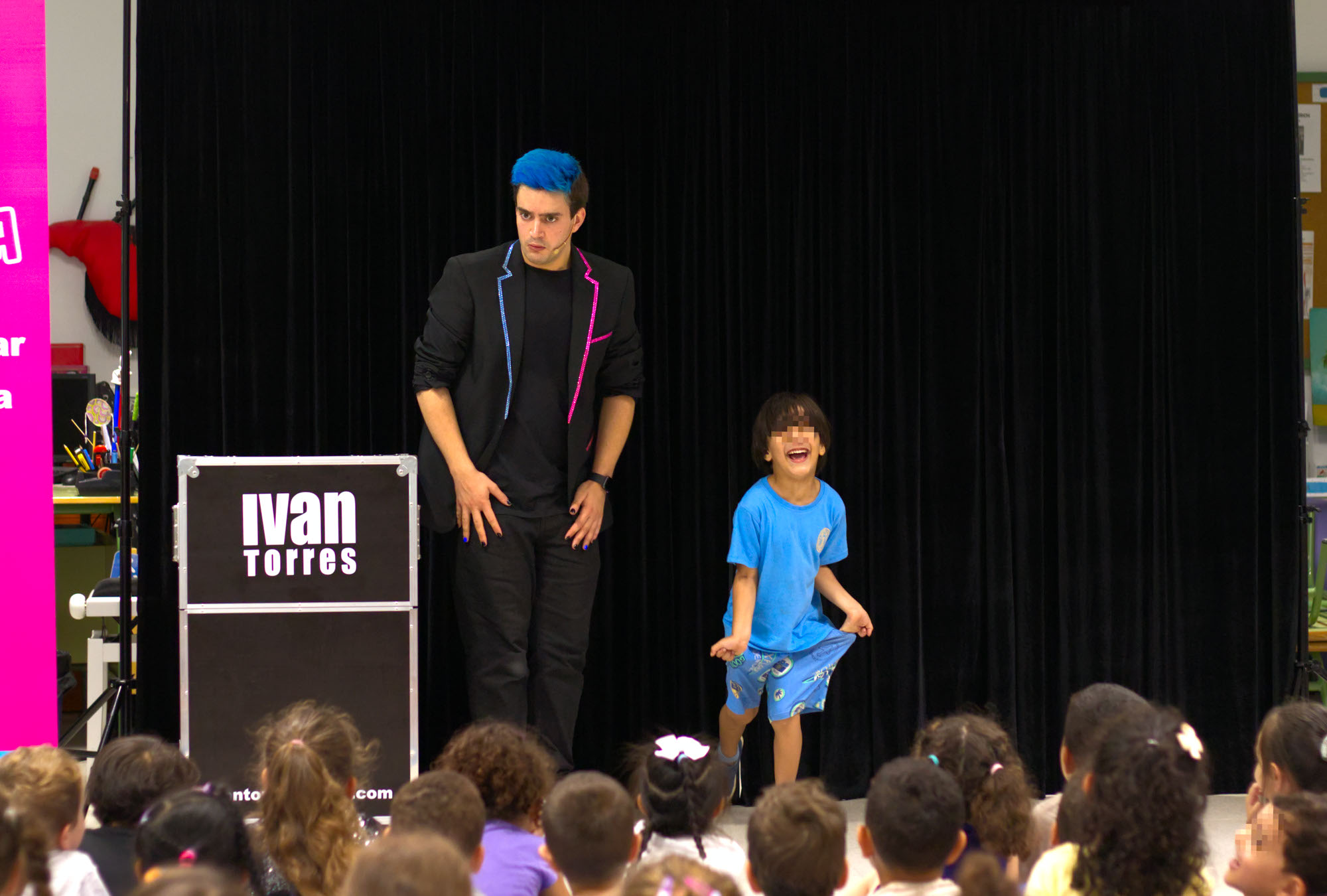 Niño riéndose vestido de azul junto con el mago para colegios Ivan Torres