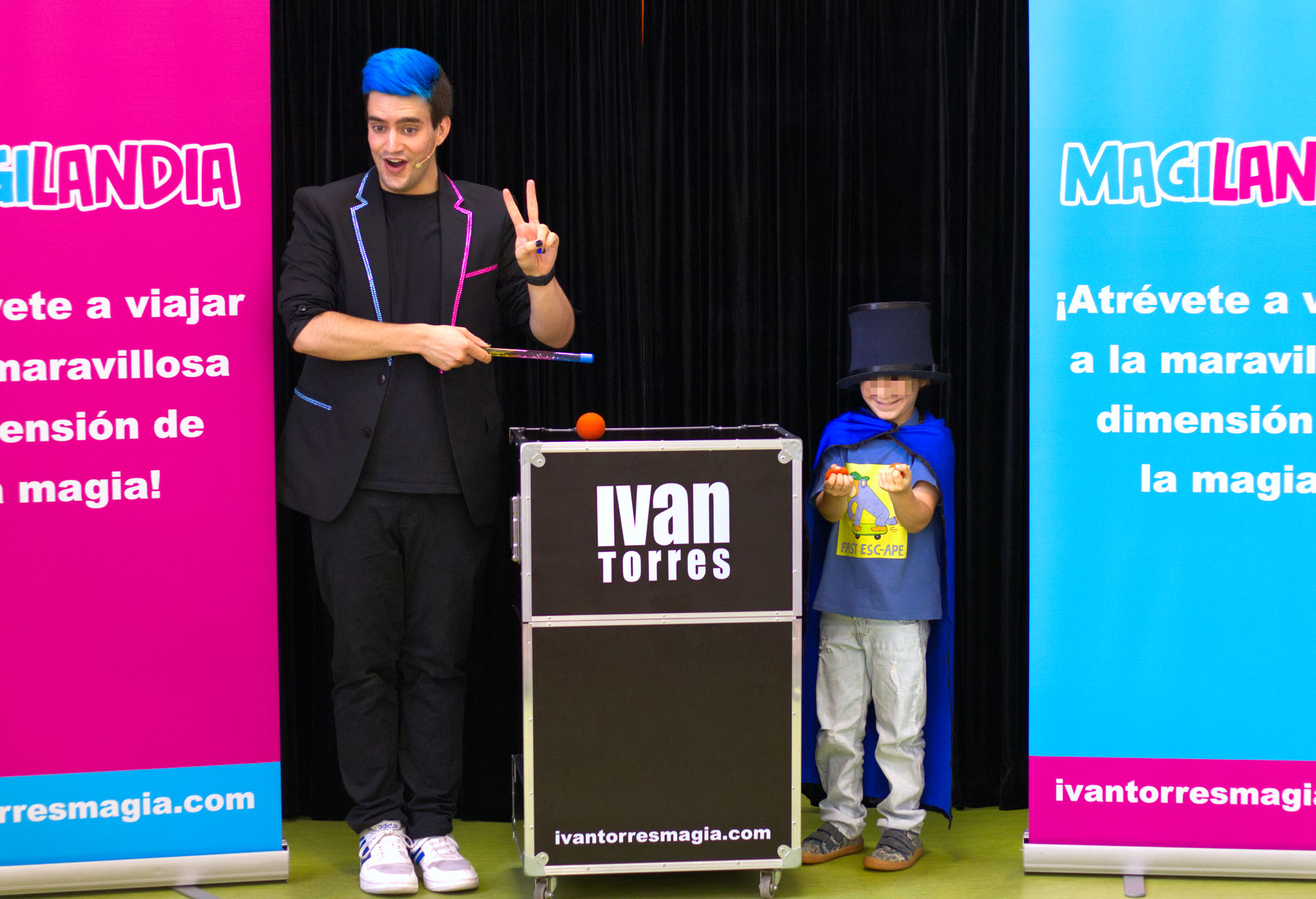 Mago para colegios Ivan Torres haciendo magia junto con un niño sonriendo por la magia