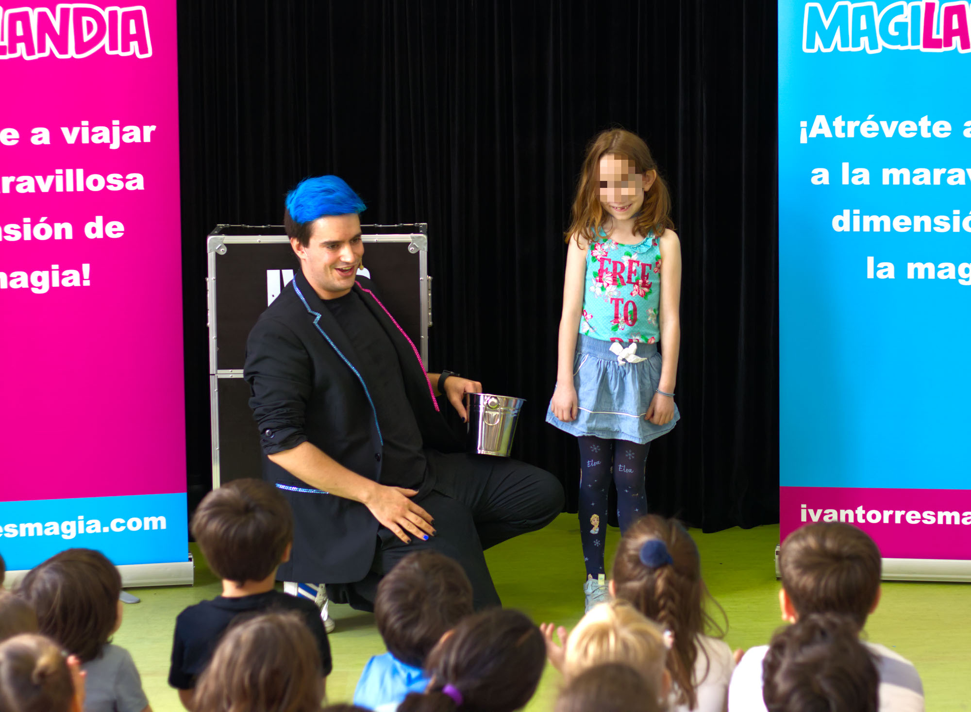 Mago para colegios Ivan Torres con un cubo en la mano junto a una niña sonriéndo