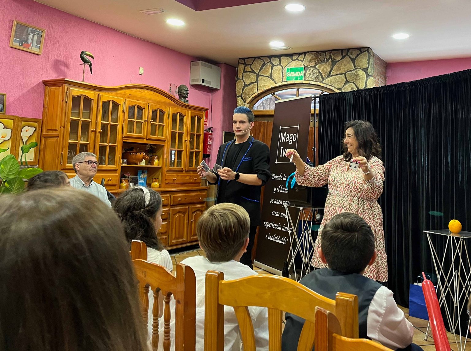 Mujer en show de magia de Ivan Torres riéndose con dos cartas.