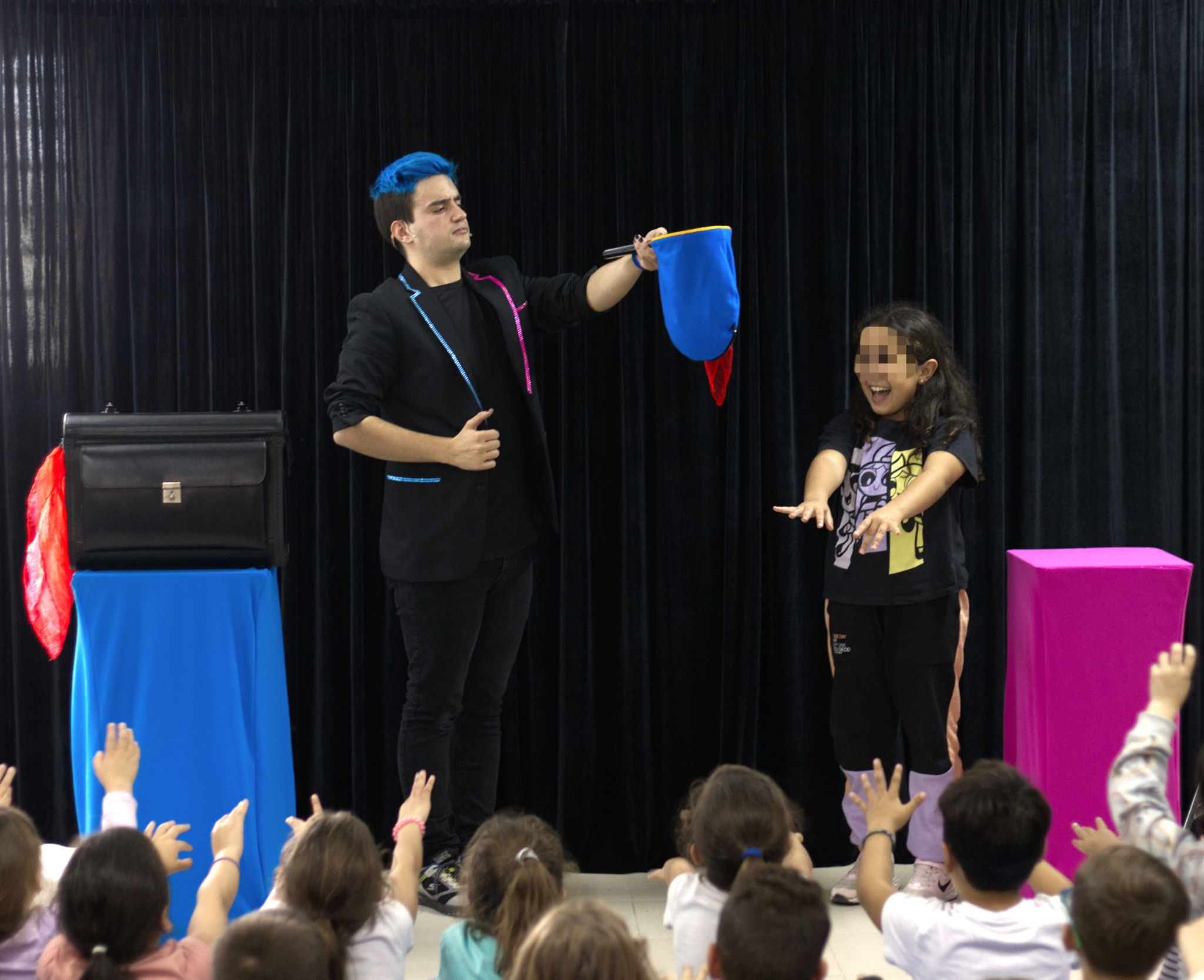 Mago para colegios Ivan Torres con una bolsa azul con una niña estirando los brazos