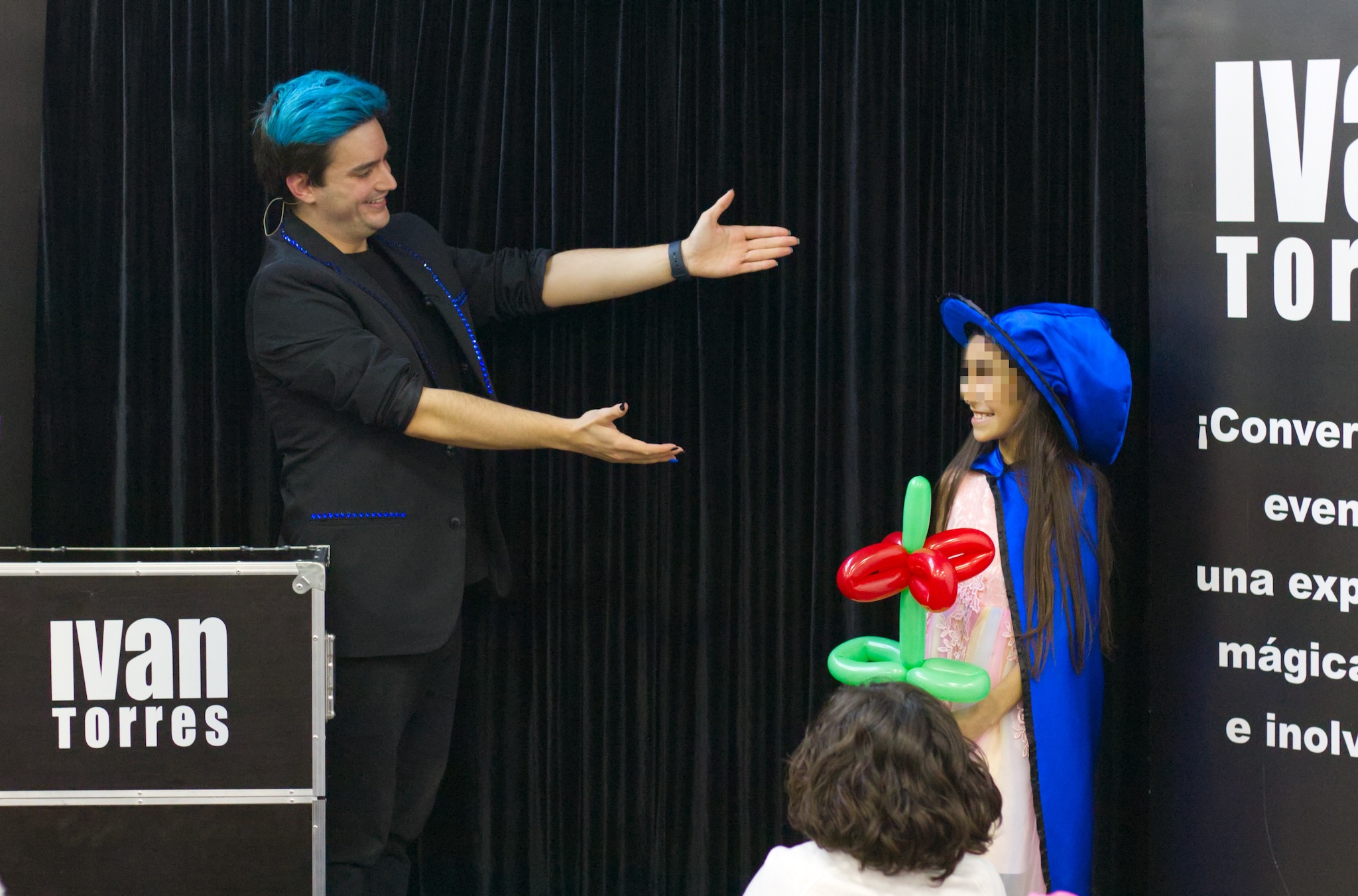 El mago Ivan Torres interactuando con una niña en su espectáculo