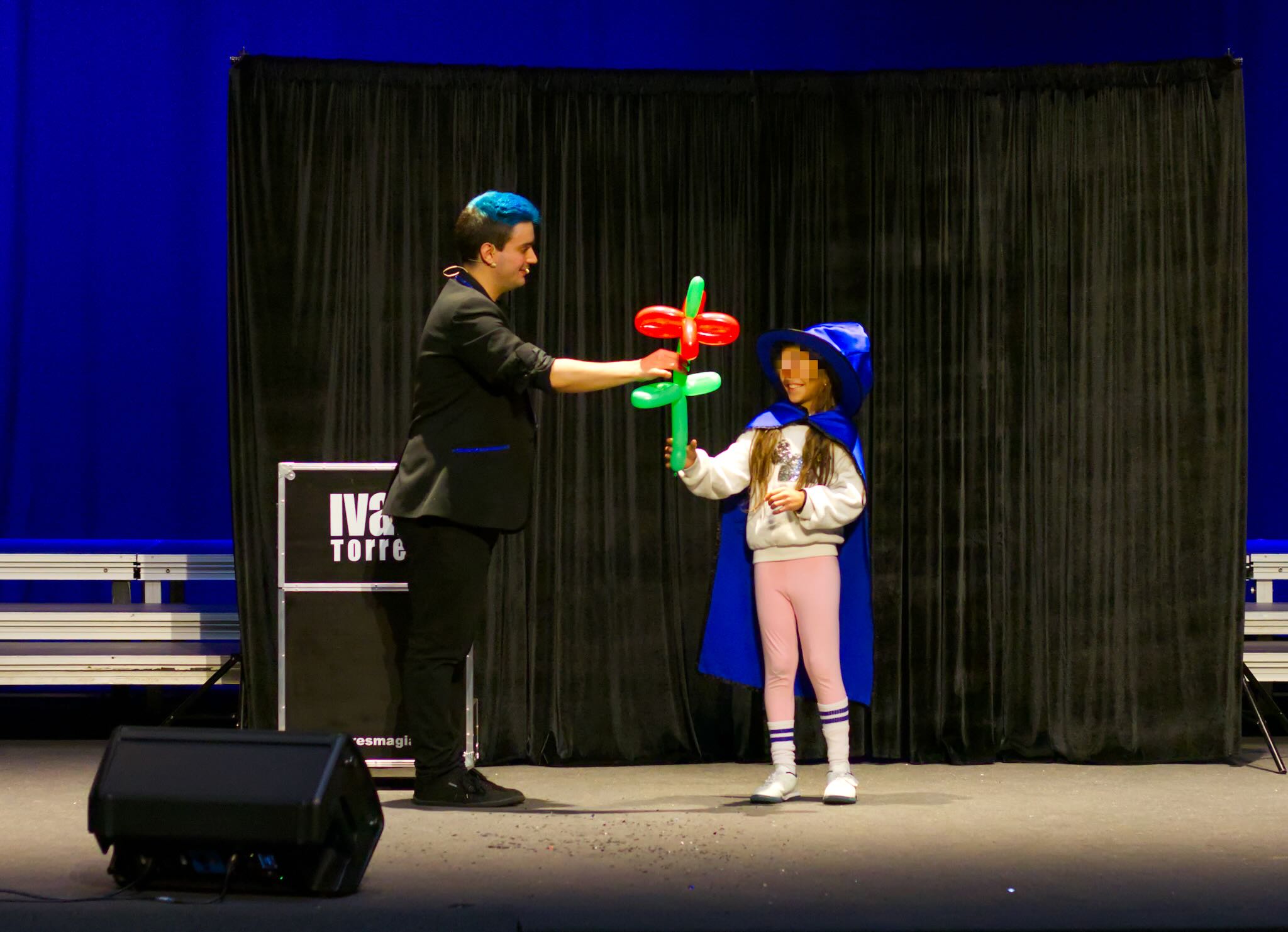 El mago Ivan Torres entregando una flor de globos a una niña.
