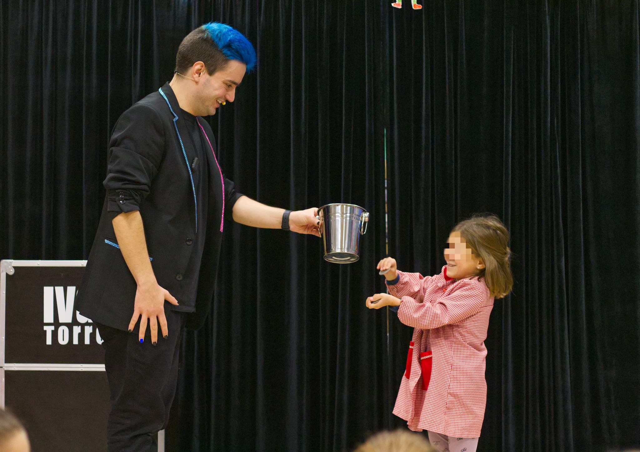 El mago Ivan Torres interactuando con una niña en su show.